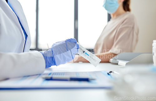 Image of female doctor with syringe and patient at hospital