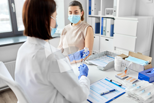 Image of female doctor with syringe vaccinating patient