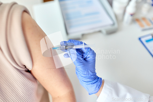 Image of close up of hand with syringe vaccinating patient