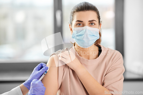 Image of female doctor with syringe vaccinating patient