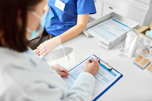 Image of doctor with clipboard and nurse at hospital