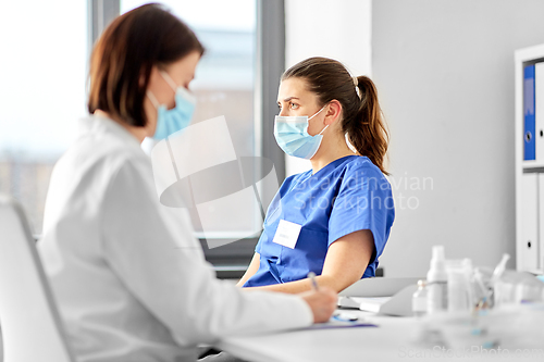 Image of doctor with clipboard and nurse at hospital