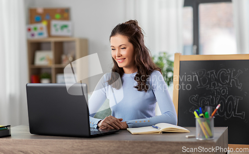 Image of teacher with laptop having online class at home