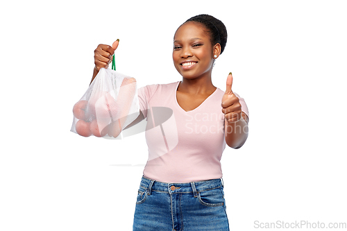Image of happy woman with vegetables in reusable net bag