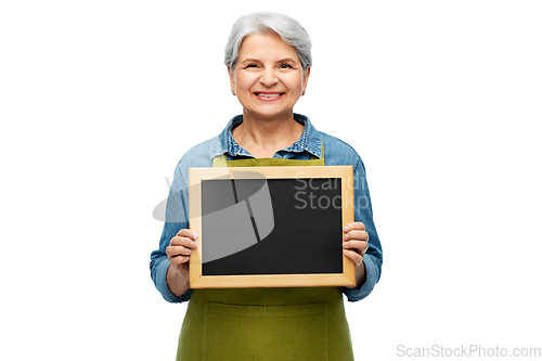 Image of happy senior woman in garden apron with chalkboard