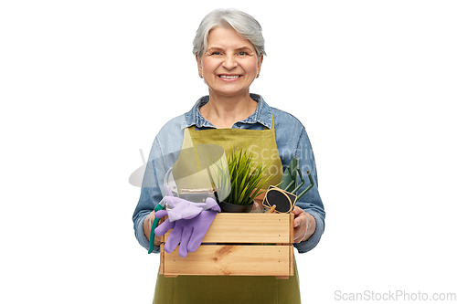 Image of smiling senior woman with garden tools in box