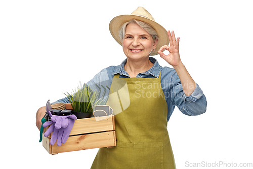 Image of old woman with garden tools in box showing ok