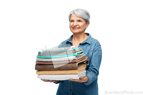 Image of smiling senior woman with clean bath towels