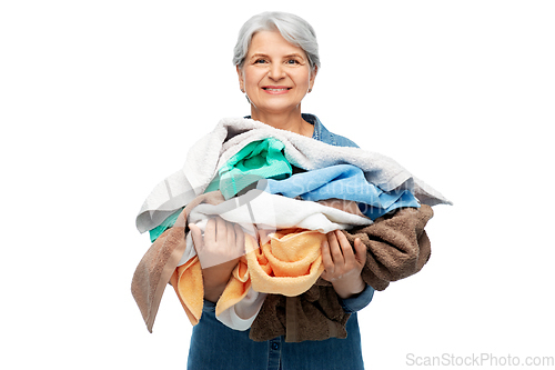 Image of smiling senior woman with heap of bath towels