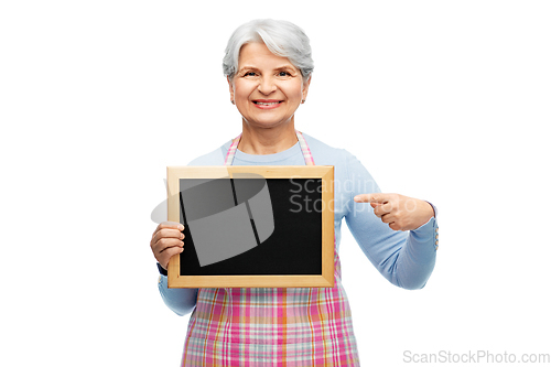 Image of smiling senior woman in apron with chalkboard