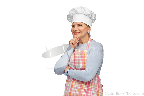 Image of smiling senior woman or chef in toque in apron