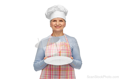 Image of smiling senior woman or chef holding empty plate