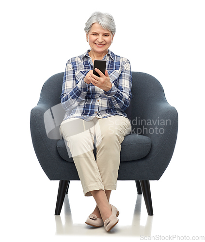 Image of smiling senior woman with smartphone in chair