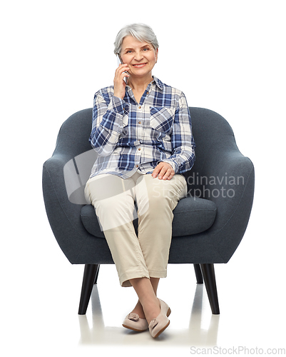 Image of senior woman calling on smartphone in armchair