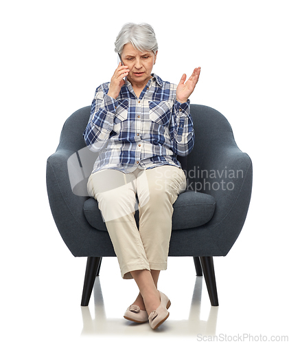 Image of senior woman calling on smartphone in armchair