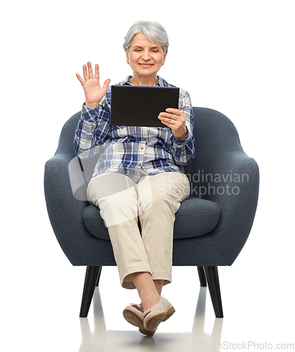Image of happy senior woman with tablet pc sitting in chair