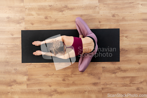 Image of woman doing yoga exercise on mat at studio