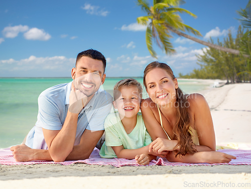 Image of happy family lying over tropical beach background