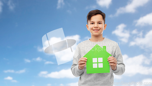 Image of smiling boy holding green house icon