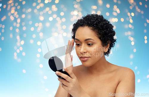 Image of african american woman looking to mirror