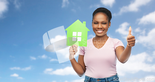 Image of smiling african american woman holding green house