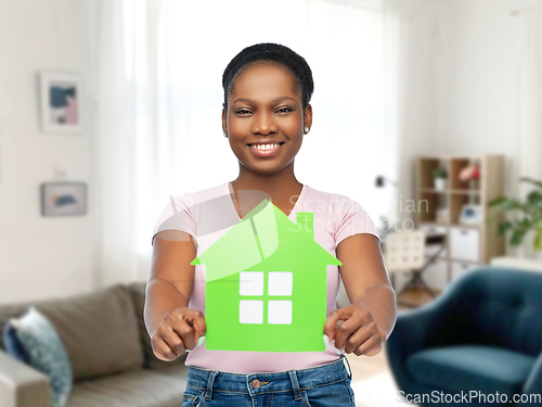 Image of smiling african american woman holding green house