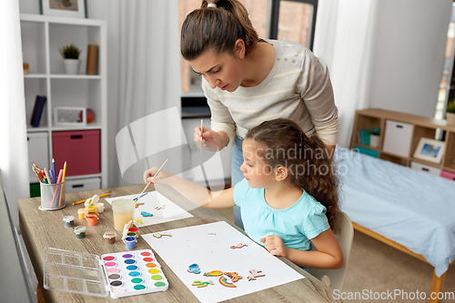 Image of mother with little daughter drawing at home