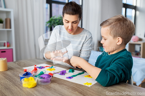 Image of mother and son playing with modeling clay at home