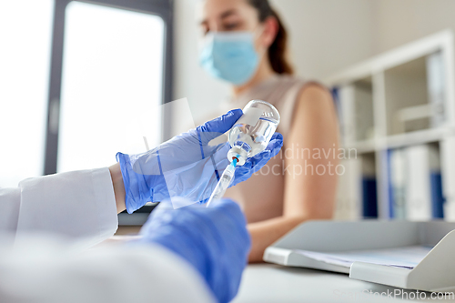 Image of female doctor with syringe vaccinating patient