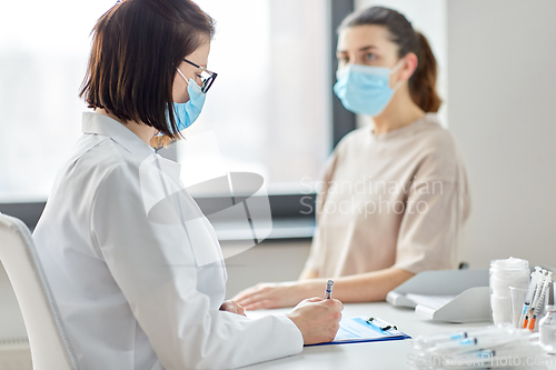 Image of doctor with clipboard and patient at hospital