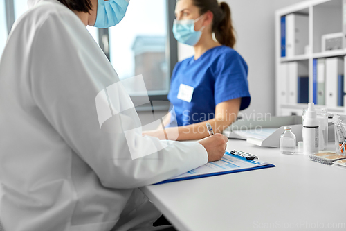 Image of doctor with clipboard and nurse at hospital