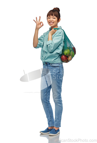 Image of happy asian woman with food in reusable string bag