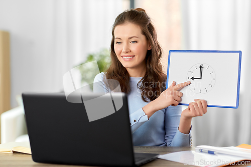 Image of teacher with clock having online class at home