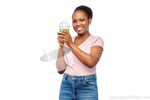 Image of happy african american woman drinking green juice