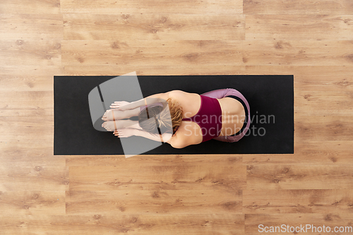 Image of woman doing yoga exercise on mat at studio