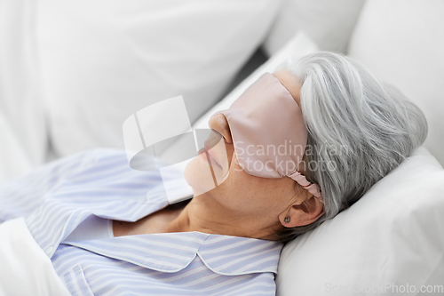 Image of senior woman with eye mask sleeping in bed at home