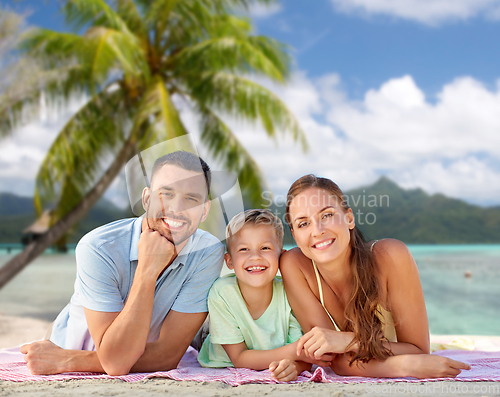 Image of happy family lying over tropical beach background