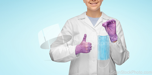 Image of female doctor with medical mask showing thumbs up