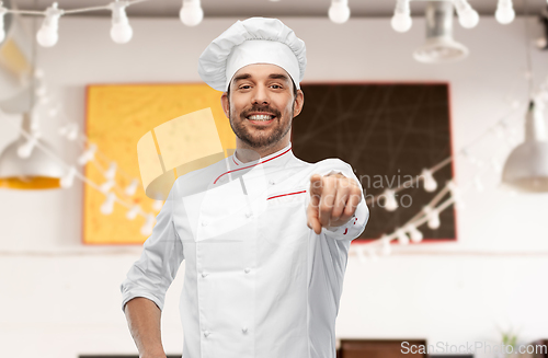 Image of happy smiling male chef in toque pointing to you