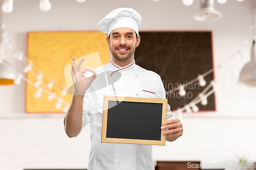 Image of happy smiling male chef showing chalkboard