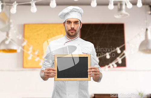 Image of male chef showing empty chalkboard at restaurant