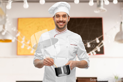 Image of happy smiling male chef with saucepan cooking food