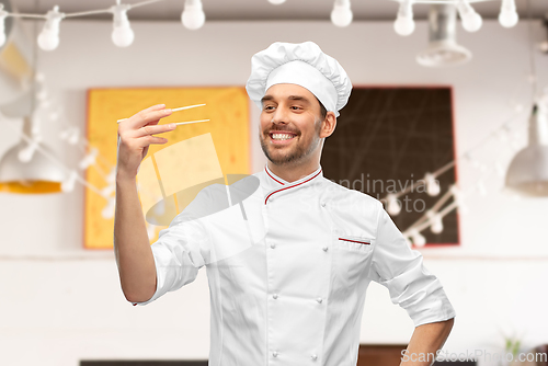 Image of happy smiling male chef with chopsticks