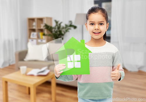 Image of smiling little girl with green house icon at home