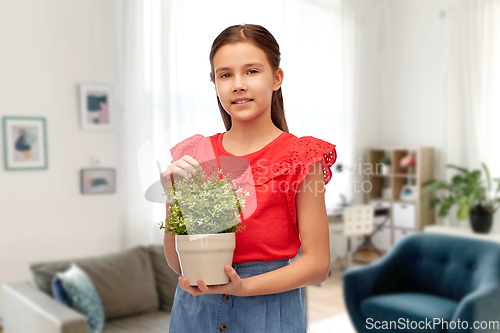 Image of happy smiling girl holding flower in pot at home