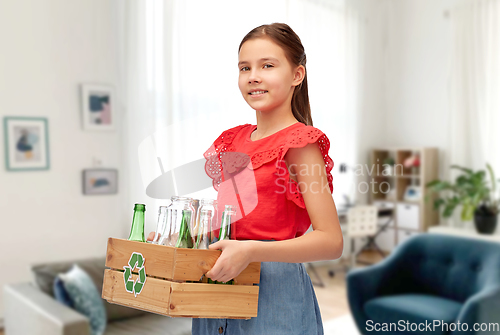 Image of smiling girl sorting glass waste at home