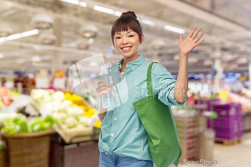 Image of woman with bag for food shopping and glass bottle