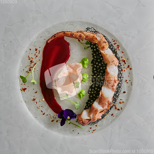 Image of Close up squid tentacles on a white plate. Top view