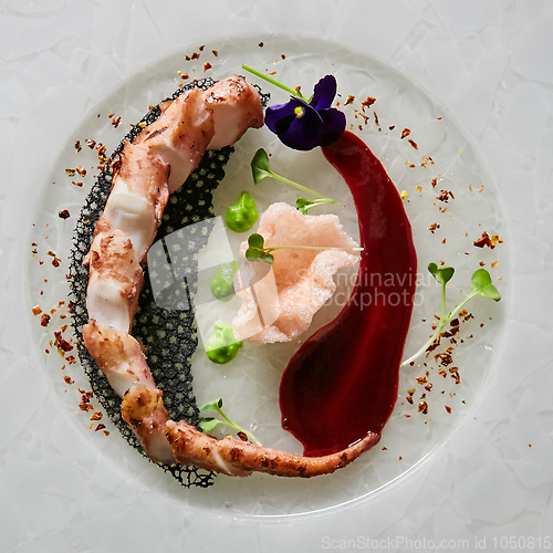 Image of Close up squid tentacles on a white plate. Top view