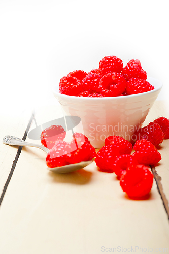 Image of bunch of fresh raspberry on a bowl and white table